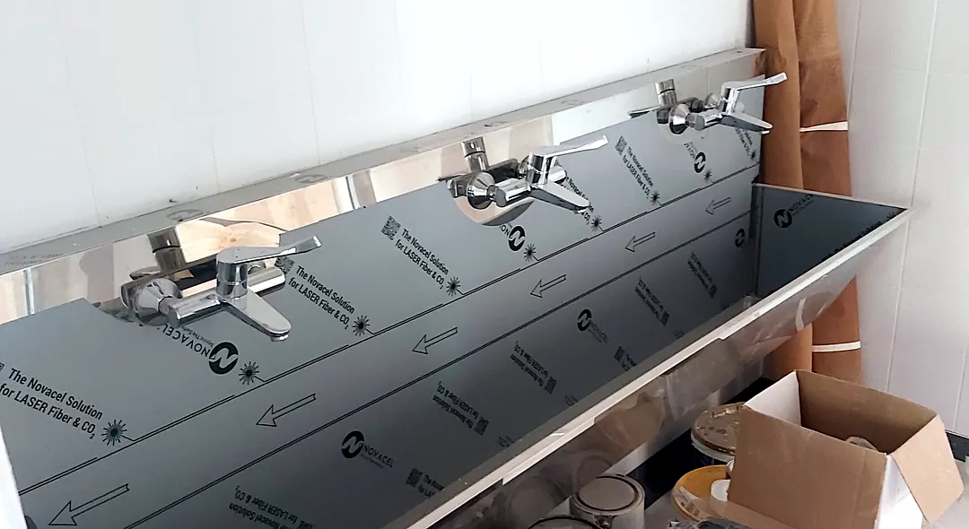 Rozsdamentes acél mosdóvályú több csapteleppel, még védőfóliával